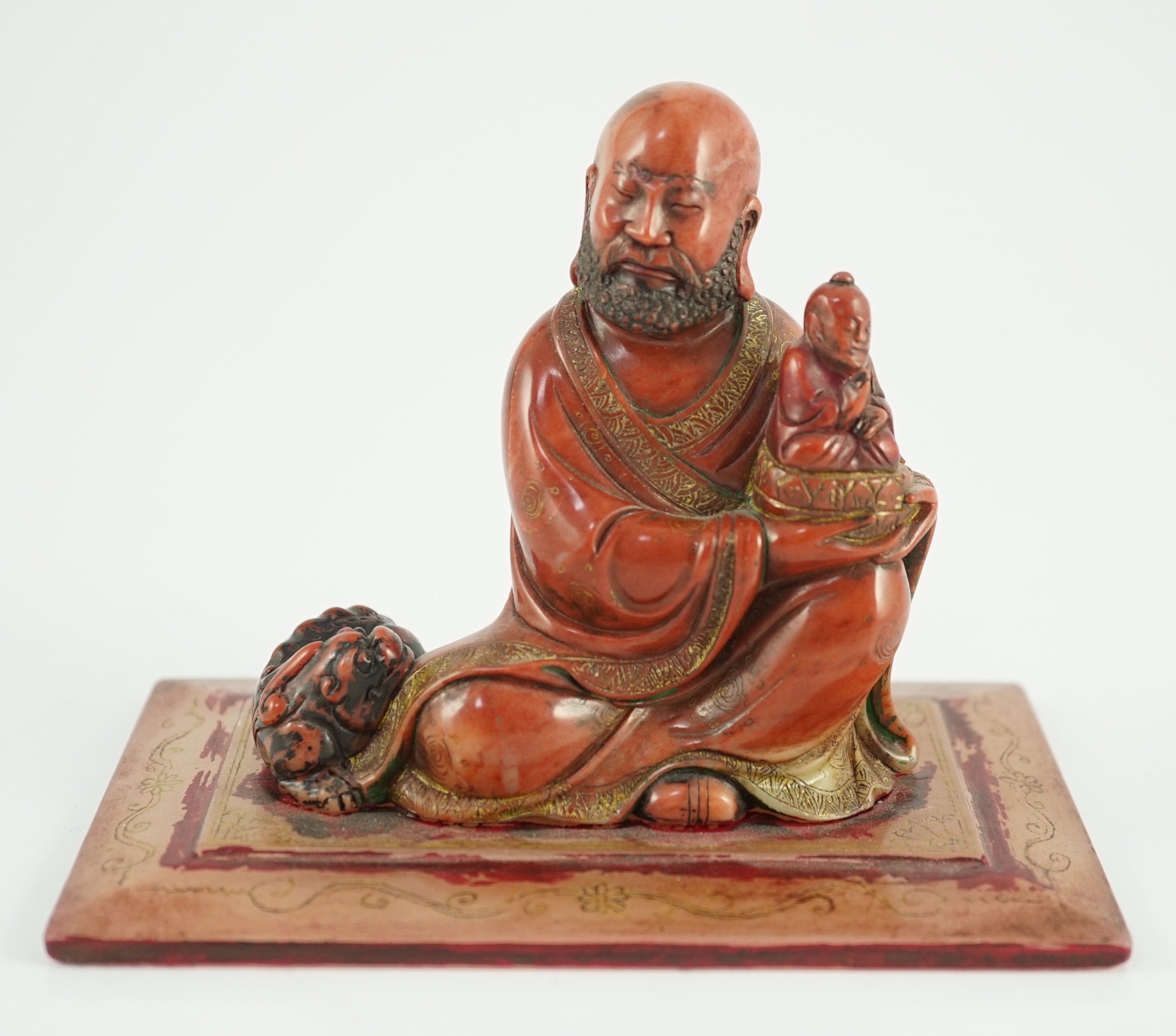 A Chinese soapstone group of a luohan holding a figure of Buddha, 18th century, 12cm wide, 9cm high